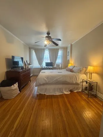 a bedroom with a bed and wooden floor