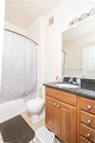 a bathroom with a granite countertop sink a toilet a mirror and shower