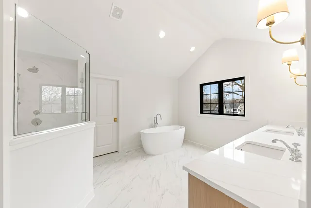 a bathroom with a sink vanity mirror and a bathtub