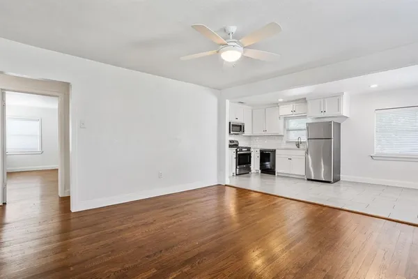 a view of a kitchen with furniture and wooden floor