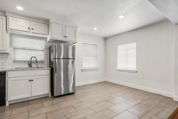 a kitchen with stainless steel appliances a refrigerator sink and cabinets