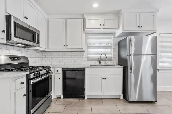 a kitchen with cabinets stainless steel appliances and a counter space