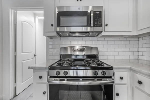 a stove top oven sitting inside of a kitchen