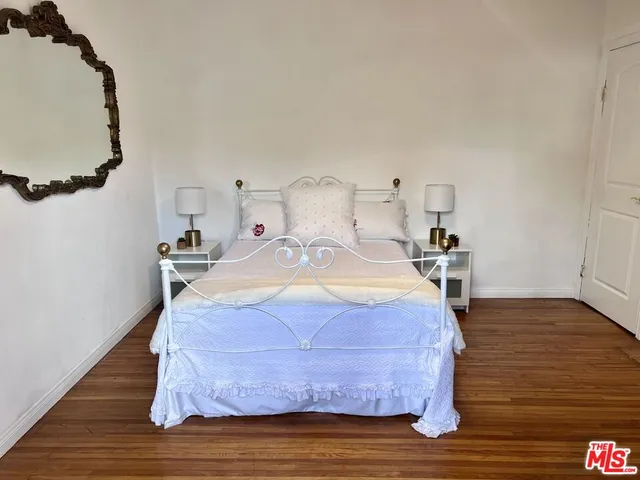 a bedroom with a bed and wooden floor