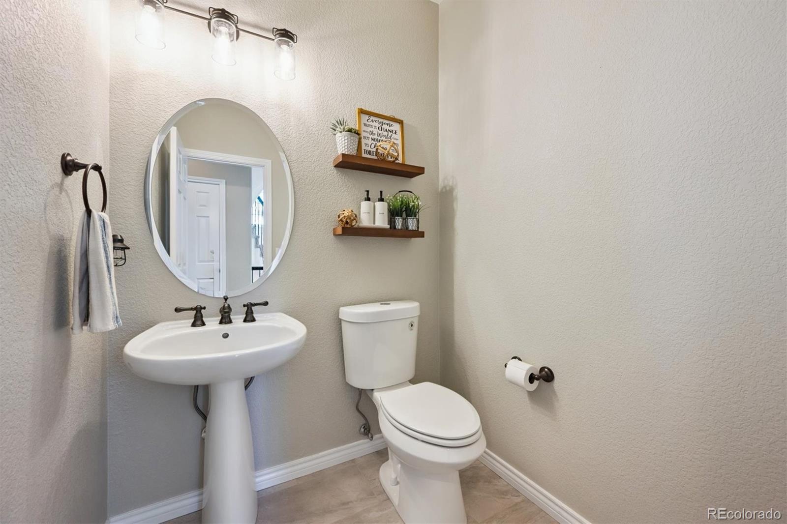 724 Imboden Road Watkins, CO 80137 - Photo 17 of 50 a bathroom with a sink toilet and a mirror