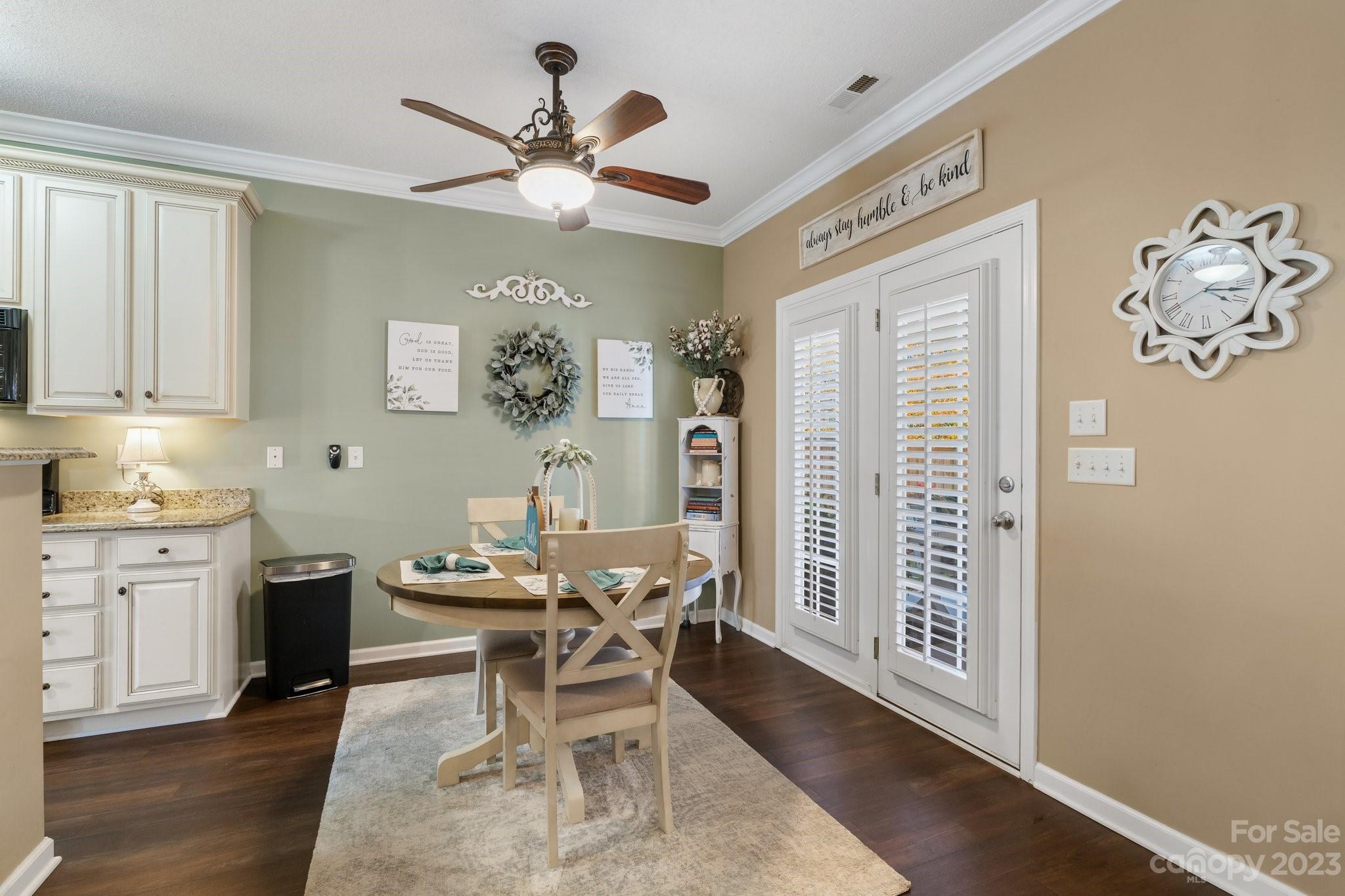 101 Woodfern Road Fletcher, NC 28732 - Photo 9 of 38 a dining room with wooden floor a chandelier fan a wooden table and chairs