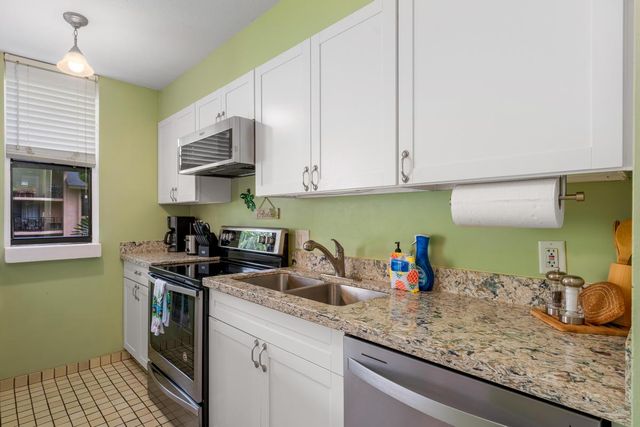 a kitchen with stainless steel appliances granite countertop a sink stove and cabinets