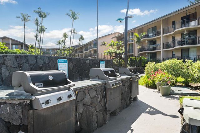 a view of a tennis ground with large trees