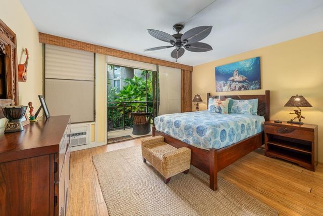 a bedroom with a bed and a flat tv screen on dresser