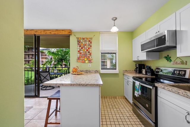 a kitchen with stainless steel appliances granite countertop a stove a sink and a microwave