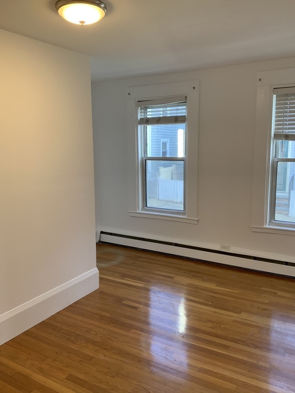27 Jenkins Street Boston, MA 02127 - Photo 7 of 23 a view of an empty room with wooden floor and a window