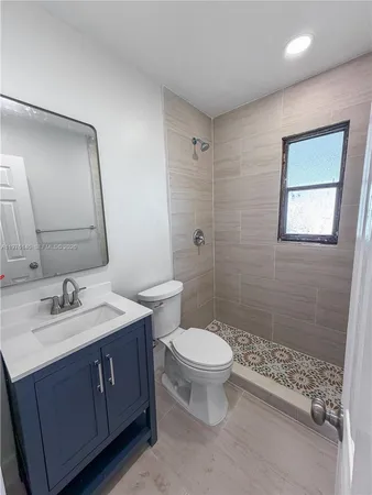 a bathroom with a double vanity sink a toilet and a mirror