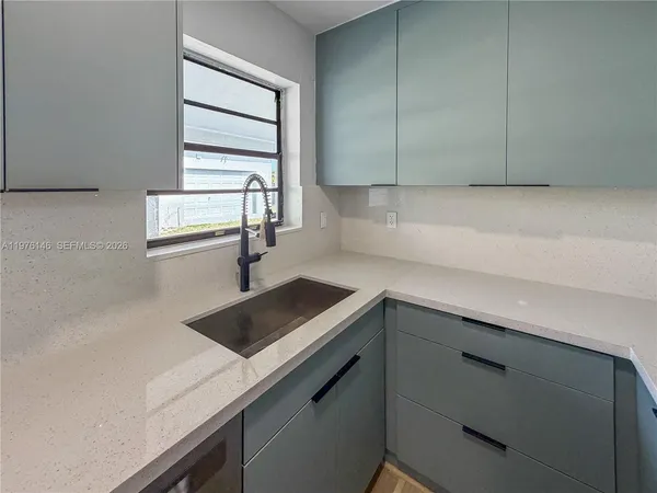 a kitchen with a sink cabinets and window