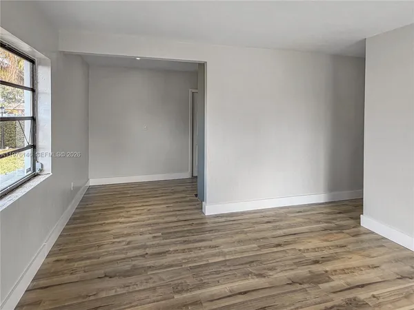 wooden floor in an empty room with a window