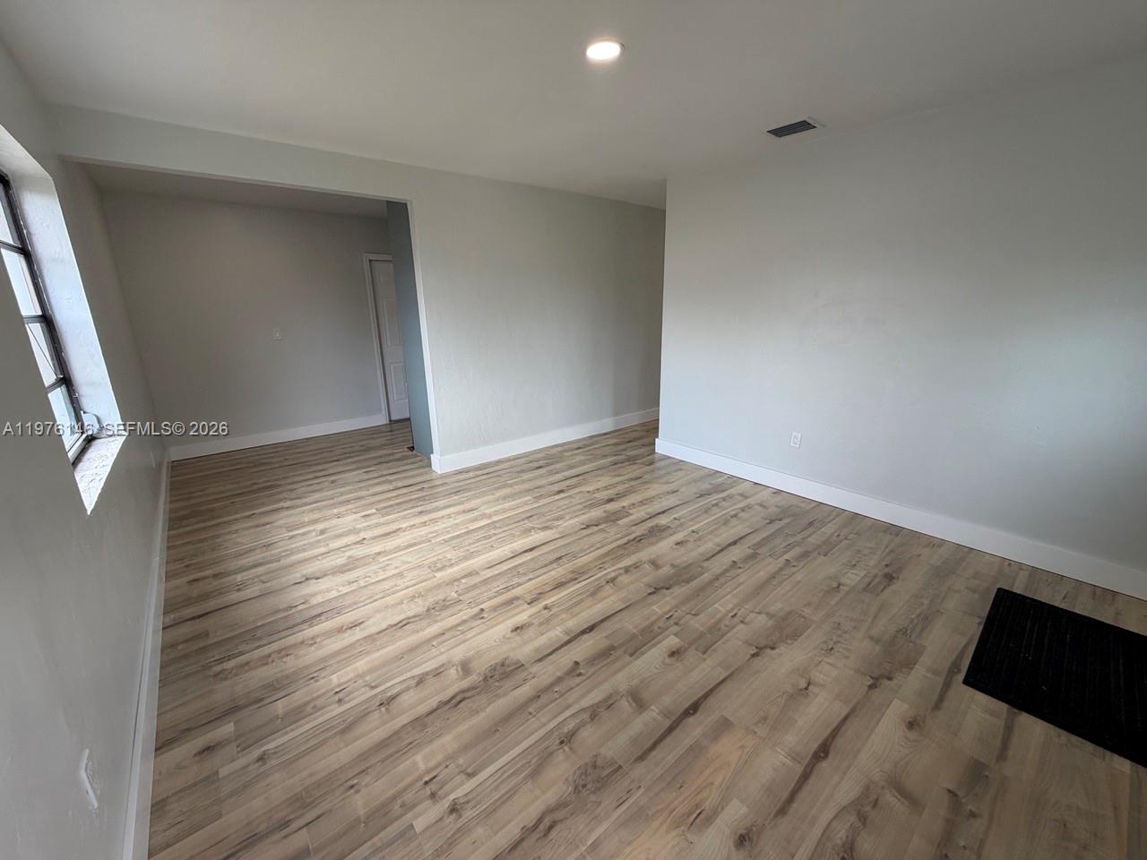 5245 Southwest 98th Court Miami, FL 33165 - Photo 7 of 22 a view of an empty room with wooden floor and a window