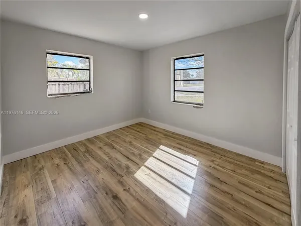 a view of a room with wooden floor and window