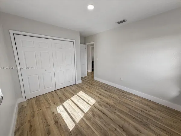 a view of an empty room and wooden floor