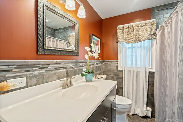 a bathroom with a sink toilet and mirror