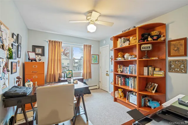 a view of a workspace with furniture and a bookshelf