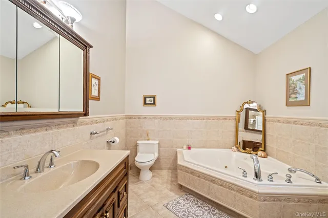 a bathroom with a tub a sink and a large mirror