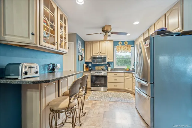 a kitchen with stainless steel appliances granite countertop a refrigerator and a stove top oven