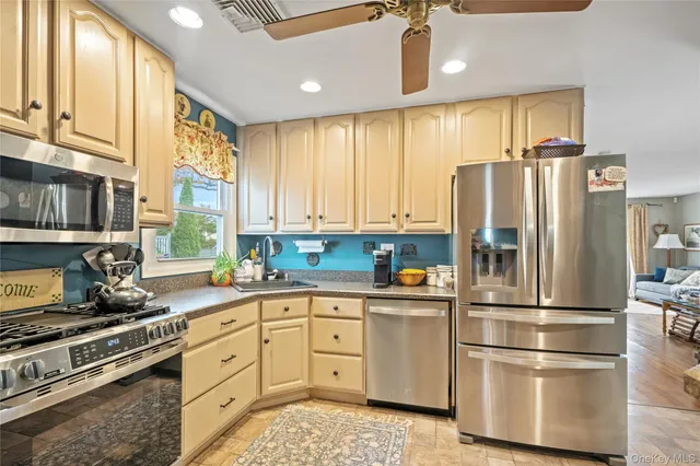 a kitchen with stainless steel appliances a refrigerator sink and cabinets