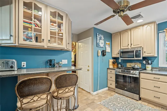 a kitchen with stainless steel appliances a stove a refrigerator and cabinets