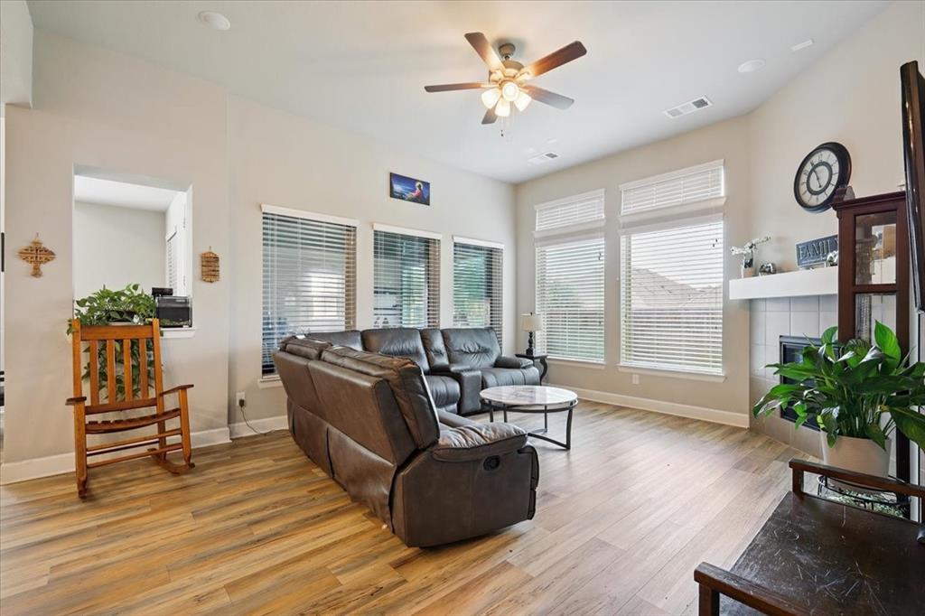 345 Greenbriar Road Little Elm, TX 75068 - Photo 5 of 20 Living area with light wood finished floors, a tile fireplace, and a ceiling fan