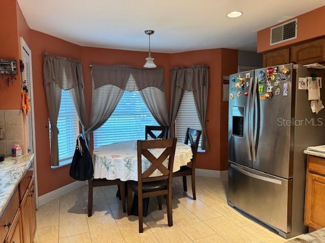 2457 Ravendale Court Kissimmee, FL 34758 - Photo 12 of 17 a kitchen with stainless steel appliances wooden floor and chairs