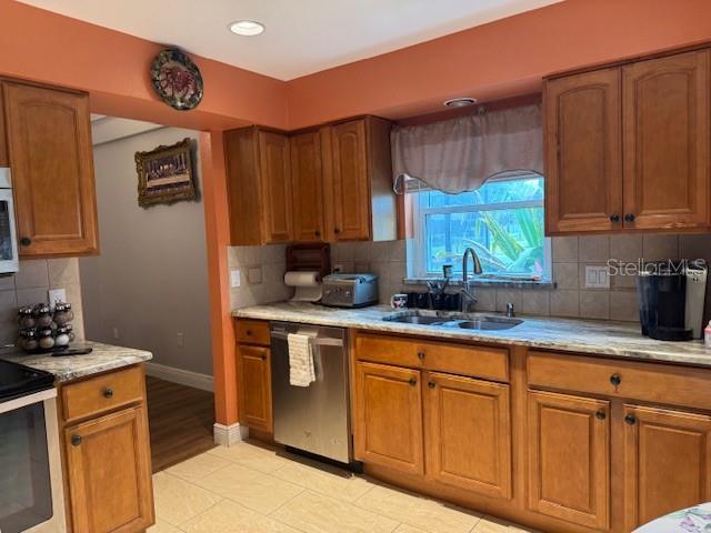 2457 Ravendale Court Kissimmee, FL 34758 - Photo 14 of 17 a kitchen with stainless steel appliances granite countertop a sink a stove cabinets and wooden floor