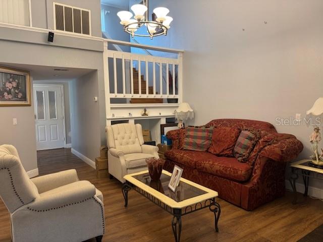 2457 Ravendale Court Kissimmee, FL 34758 - Photo 5 of 17 a living room with furniture a chandelier and wooden floor