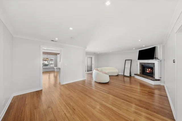 a view of empty room with wooden floor and fireplace