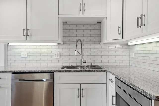 a kitchen with granite countertop white cabinets and white appliances