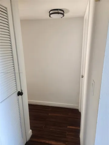 a close view of a refrigerator in kitchen and an empty room