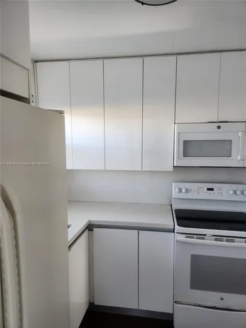 a view of a hallway with wooden floor and furniture