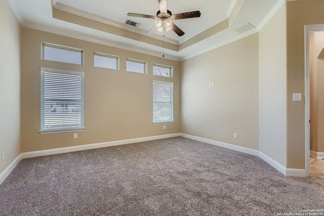 en empty room with windows and ceiling fan