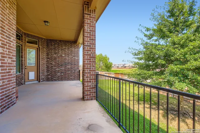 a view of a backyard with a huge green area and wooden fence