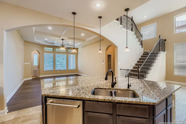 a kitchen with granite countertop a sink and wooden floor