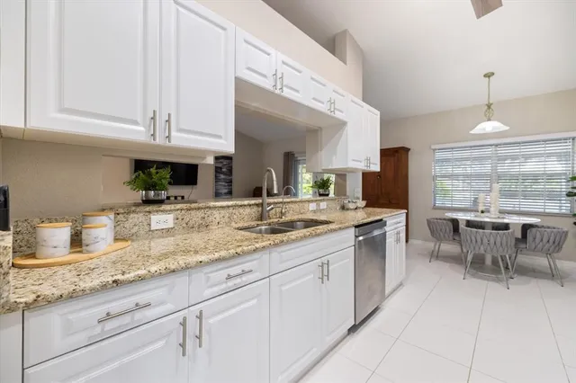 a bedroom with a bed a chandelier and a dresser