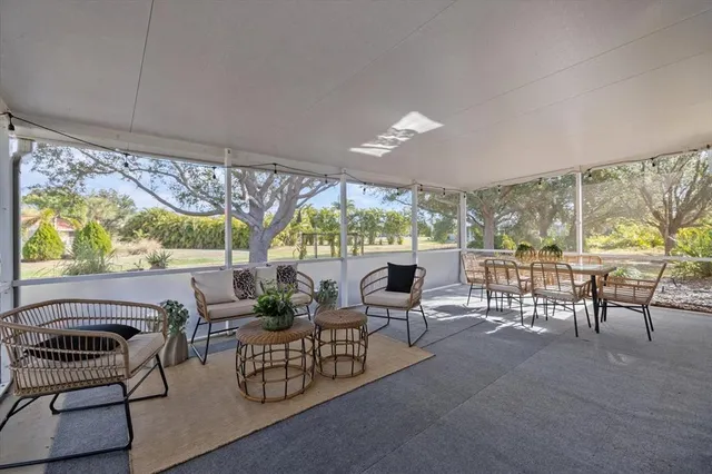 a dining room with furniture and large windows