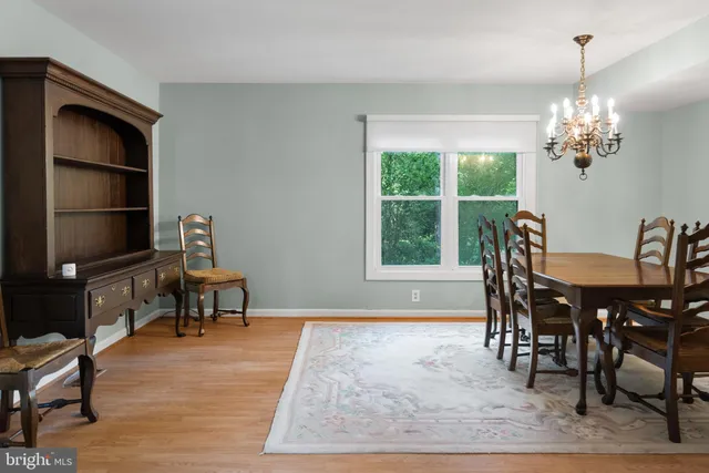 a view of a dining room with furniture a chandelier and wooden floor