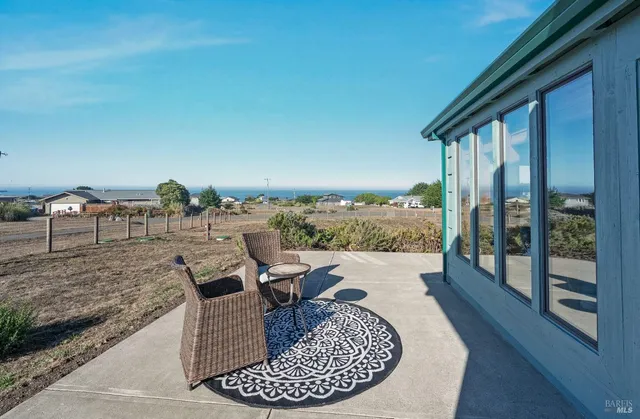 a view of a sign board with a house in the background