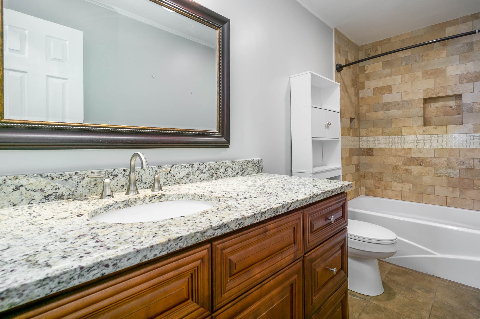 106 Jordan Avenue Mount Pleasant, TN 38474 - Photo 17 of 30 a bathroom with a granite countertop sink a toilet and bathtub