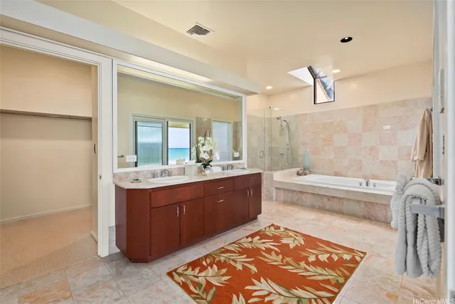 a spacious bathroom with a tub sink and mirror