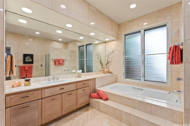 a spacious bathroom with a large tub sink and mirror