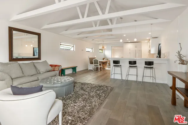 a living room with furniture and view of kitchen
