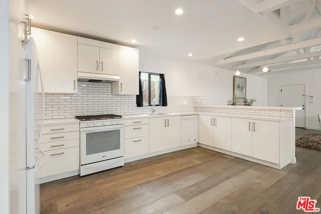 a kitchen with white cabinets stainless steel appliances and sink