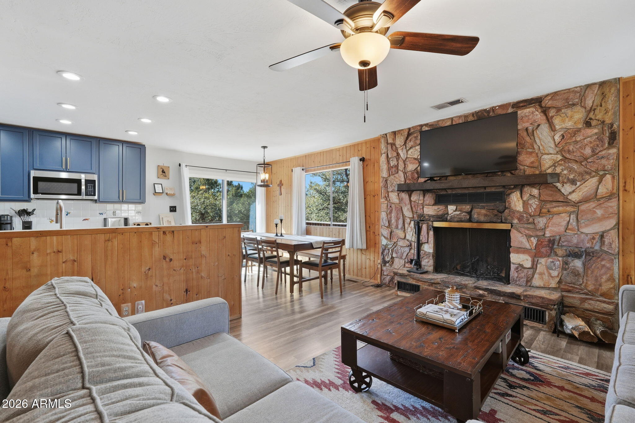 8247 Ralls Drive Pine, AZ 85544 - Photo 9 of 50 a living room with furniture a flat screen tv and a fireplace