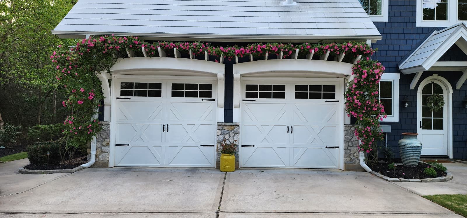 10 Riata Drive Magnolia, TX 77354 - Photo 12 of 48 This charming home features a two-car garage with decorative carriage-style doors and elegant stone accents. Lush greenery and vibrant flowering vines enhance the inviting curb appeal. Inside garage find epoxy flooring and 240v charging capability.