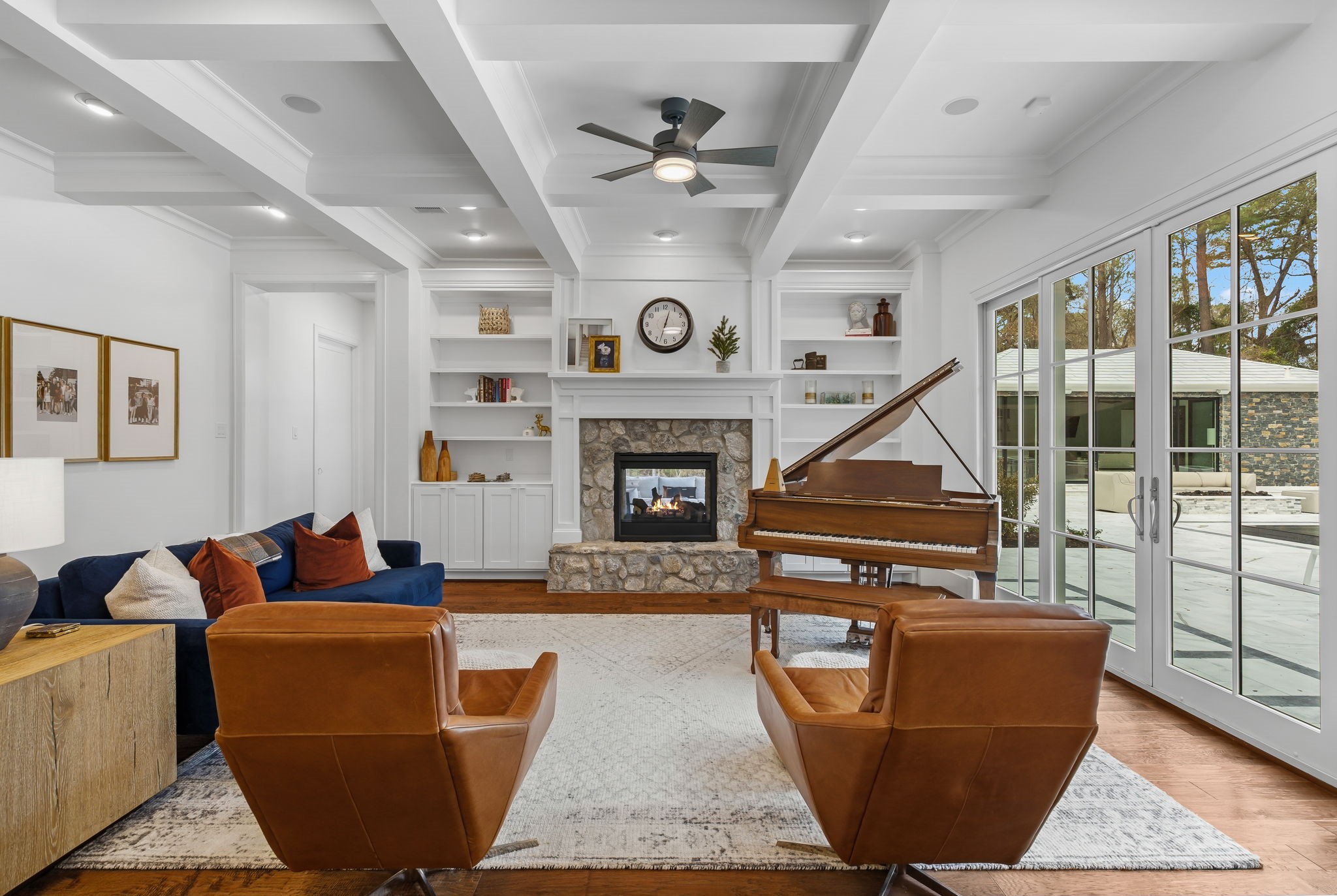10 Riata Drive Magnolia, TX 77354 - Photo 18 of 48 Family room with coffered ceilings and beams, built-ins, double-sided fireplace and double doors that open to the resort-like backyard.